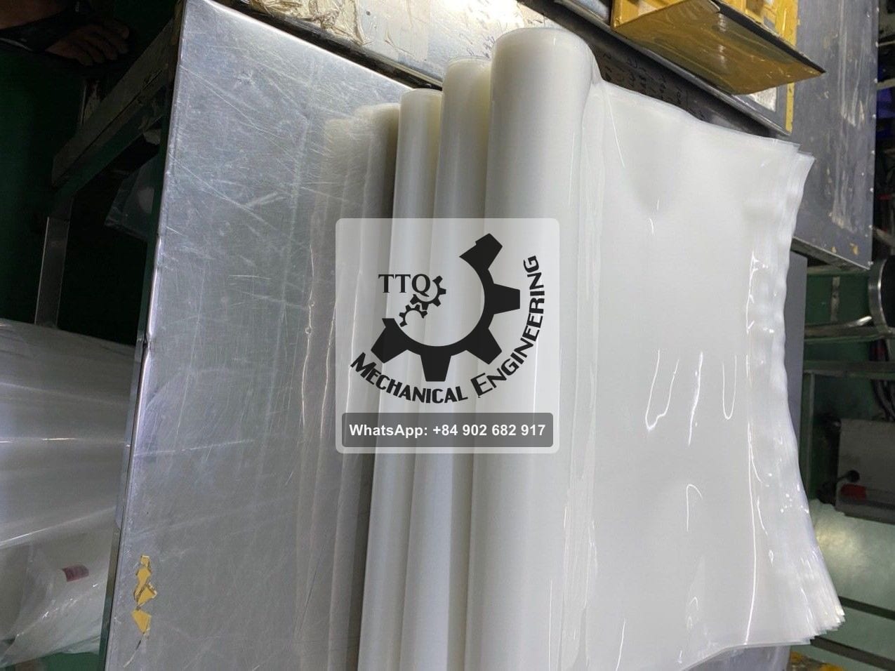 A stack of clear vacuum-pack bags beside the machine