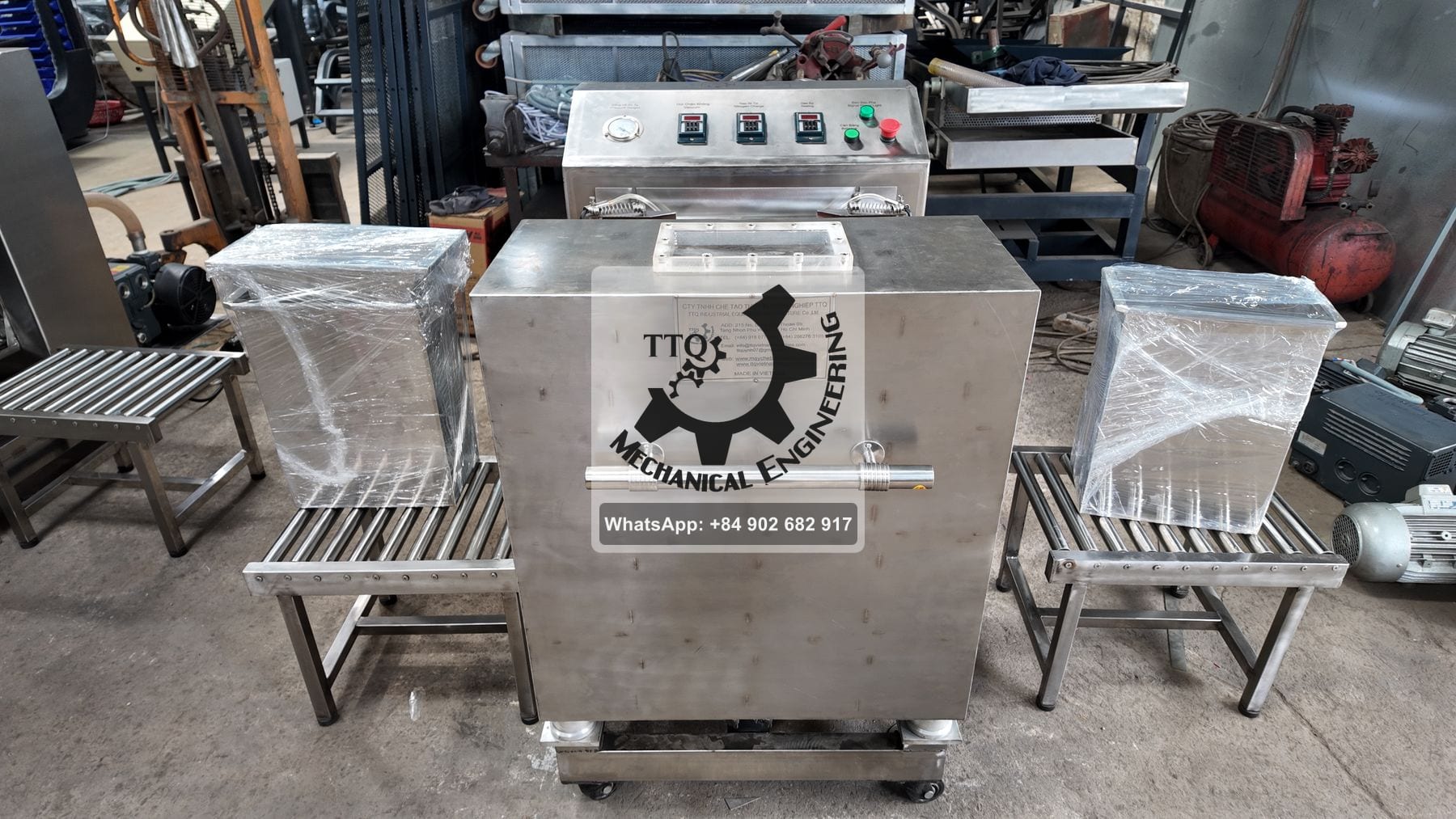 A TTQ vacuum packing machine with roller tables either side; its panel reads vacuum, nitrogen charge and sealing